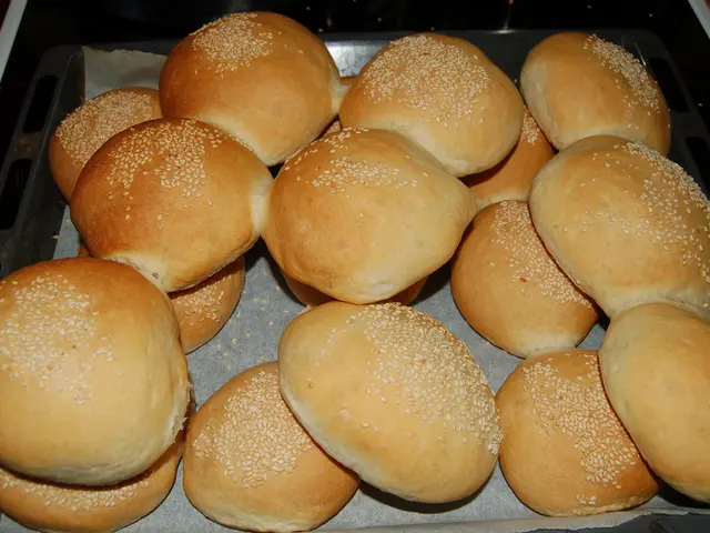 In this picture we can see buns and paper in a container.